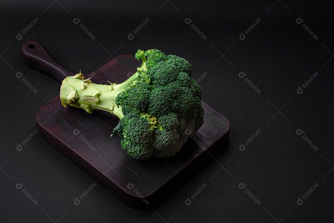 Brócolis fresco cru em uma mesa de cozinha preta. Cozinhando comida vegana