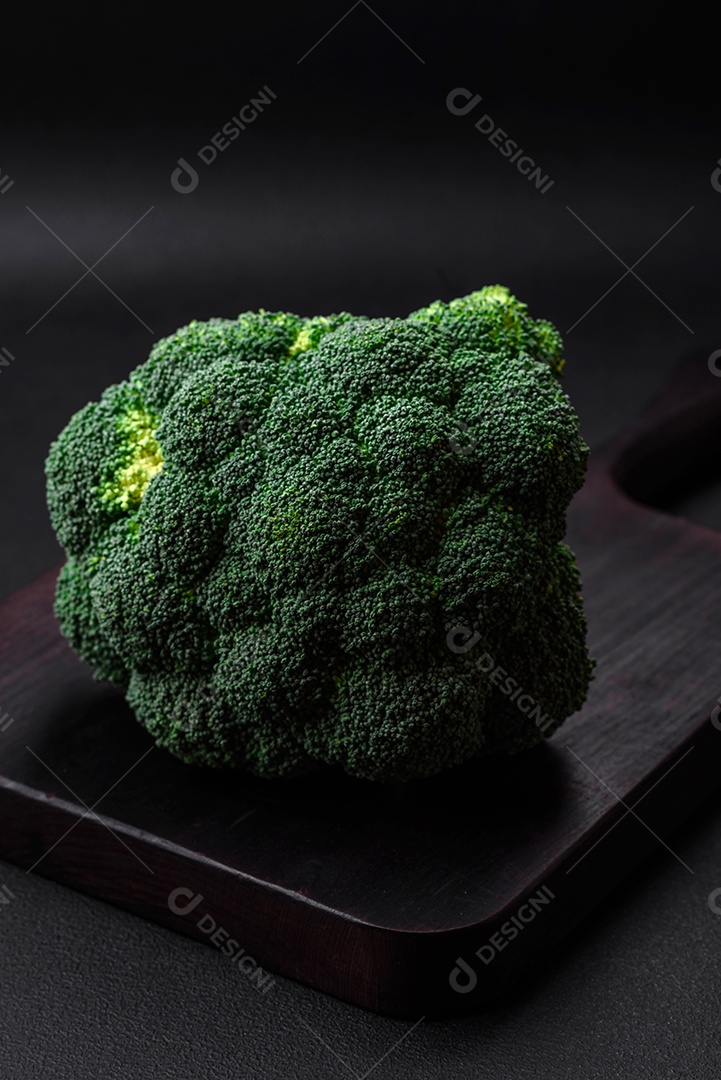 Brócolis fresco cru em uma mesa de cozinha preta. Cozinhando comida vegana