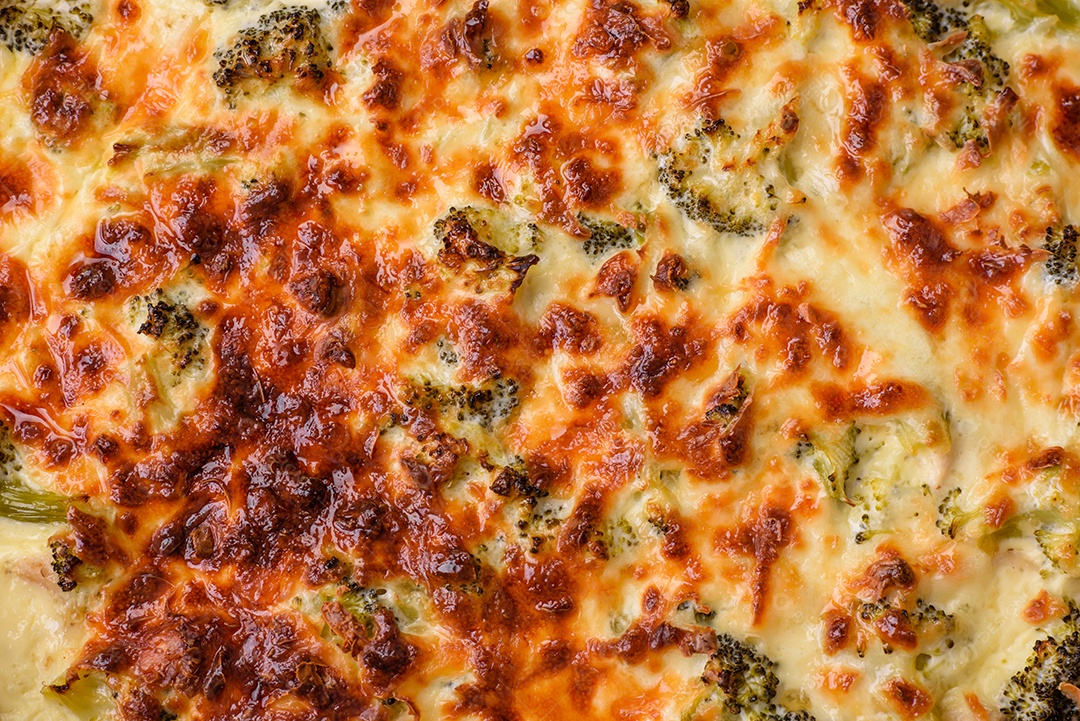 Deliciosa quiche com brócolis, queijo, frango, especiarias e ervas sobre um fundo escuro de concreto