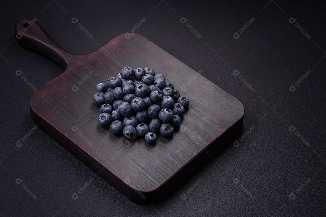 Deliciosos mirtilos frescos em um fundo de concreto preto textural. Colhendo frutas da estação