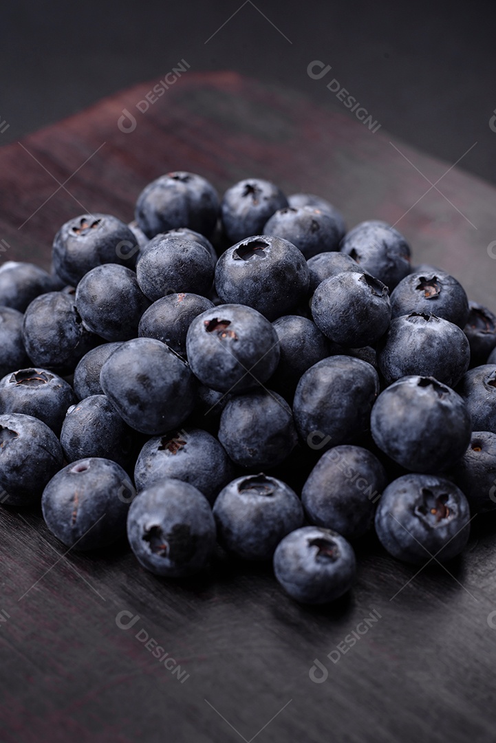 Deliciosos mirtilos frescos em um fundo de concreto preto textural. Colhendo frutas da estação