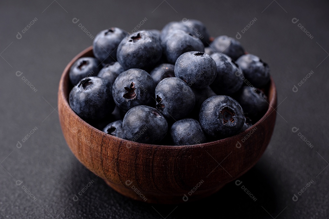 Deliciosos mirtilos frescos em um fundo de concreto preto textural. Colhendo frutas da estação