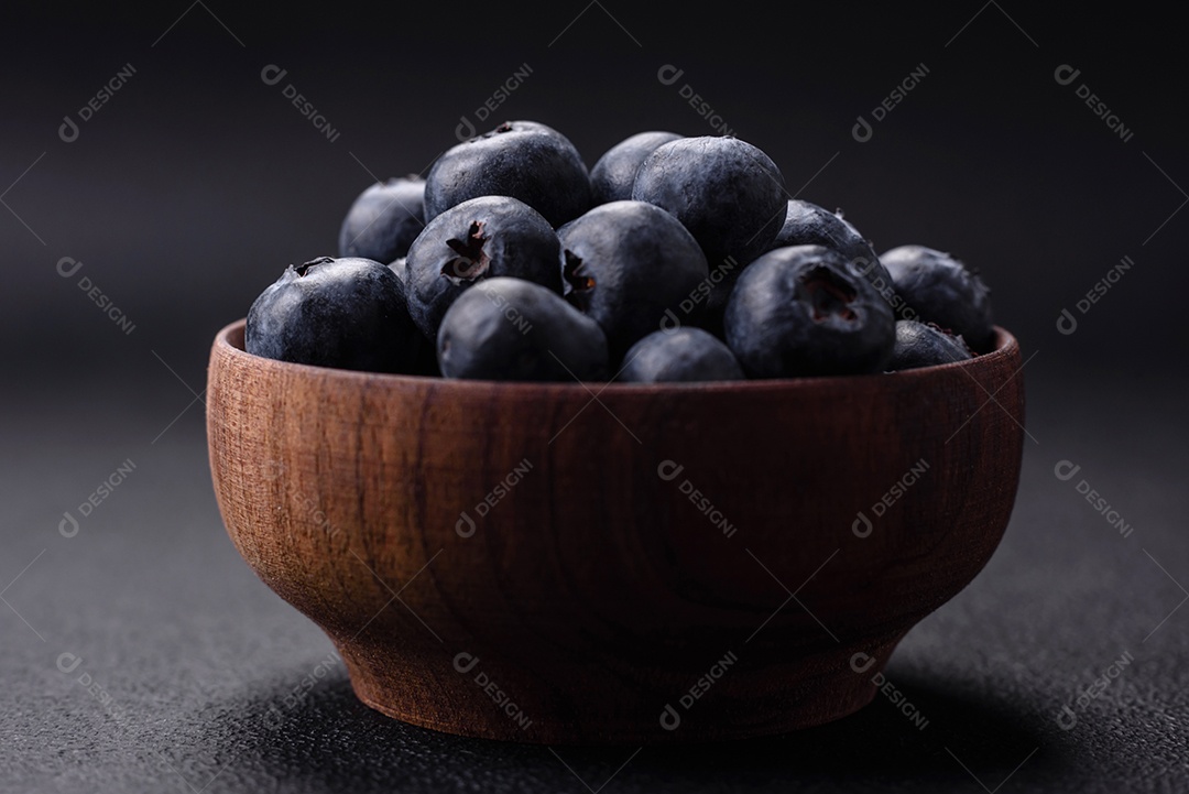 Deliciosos mirtilos frescos em um fundo de concreto preto textural. Colhendo frutas da estação