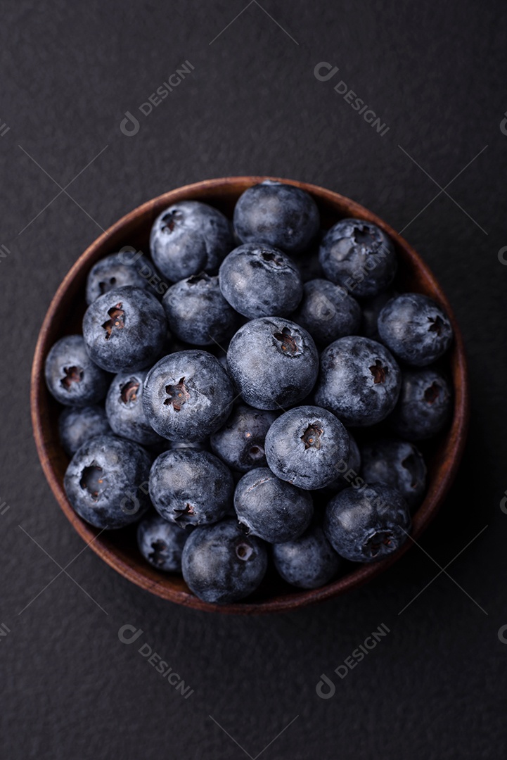 Deliciosos mirtilos frescos em um fundo de concreto preto textural. Colhendo frutas da estação