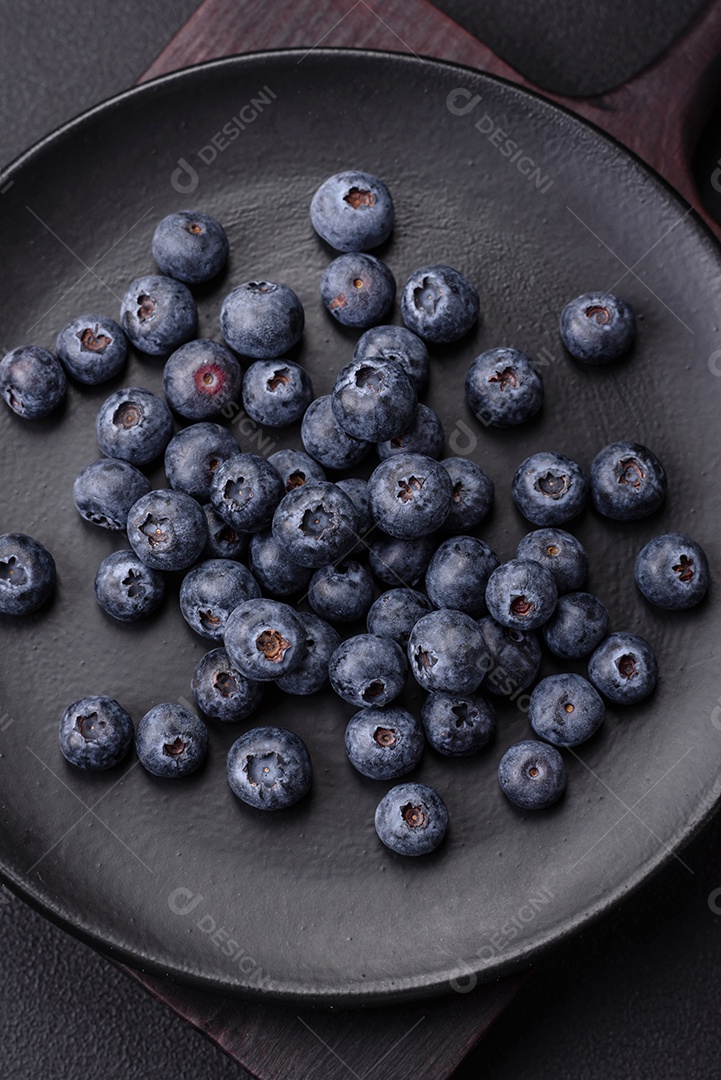 Deliciosos mirtilos frescos em um fundo de concreto preto textural. Colhendo frutas da estação