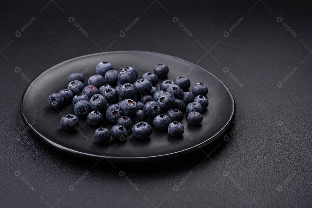 Deliciosos mirtilos frescos em um fundo de concreto preto textural. Colhendo frutas da estação