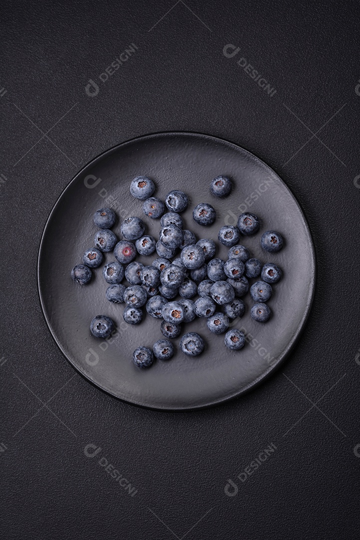 Deliciosos mirtilos frescos em um fundo de concreto preto textural. Colhendo frutas da estação