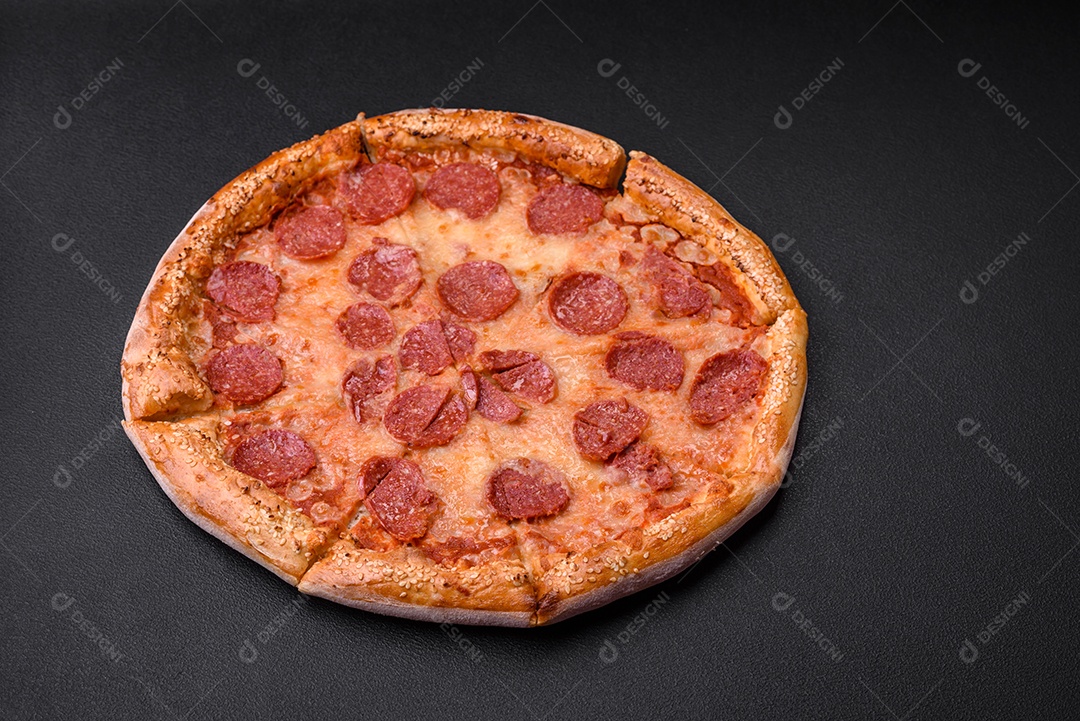 Deliciosa pizza de pepperoni fresca com sementes de gergelim nas laterais sobre um fundo de concreto preto