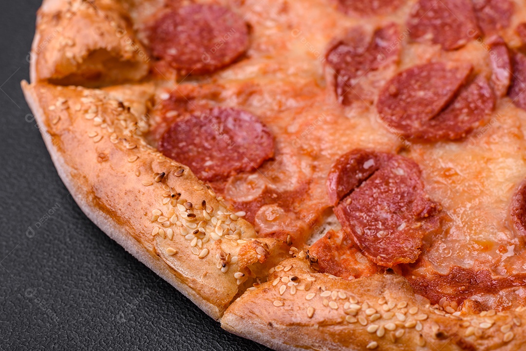Deliciosa pizza de pepperoni fresca com sementes de gergelim nas laterais sobre um fundo de concreto preto