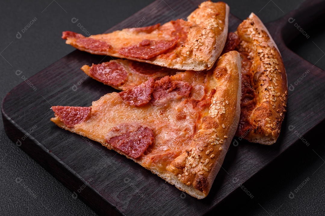 Deliciosa pizza de pepperoni fresca com sementes de gergelim nas laterais sobre um fundo de concreto preto