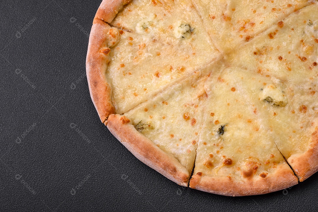 Deliciosa pizza quente fresca quatro queijos sobre um fundo de concreto preto