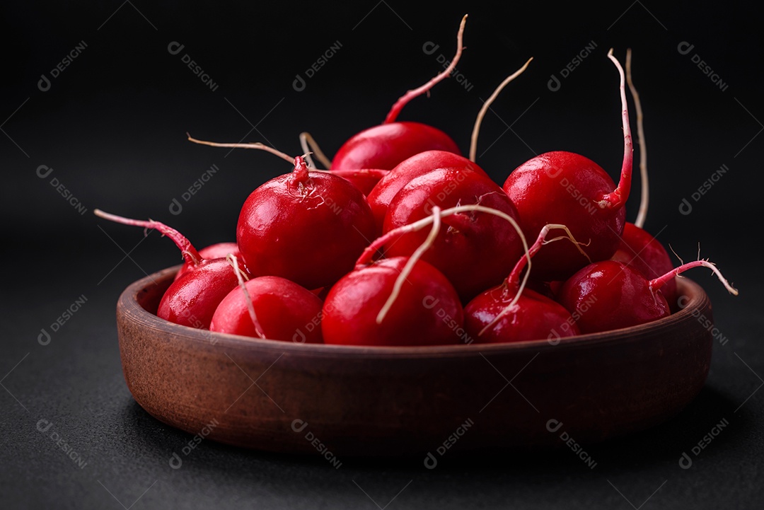 Delicioso rabanete vermelho cru fresco para fazer salada saudável em fundo escuro de concreto