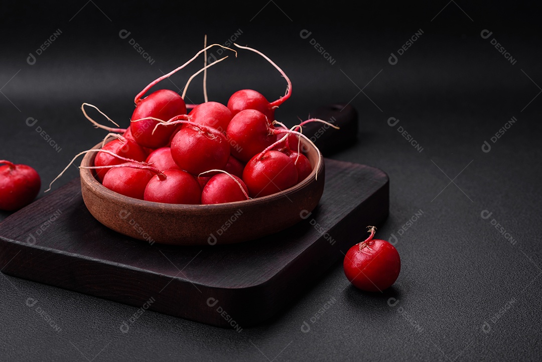 Delicioso rabanete vermelho cru fresco para fazer salada saudável em fundo escuro de concreto