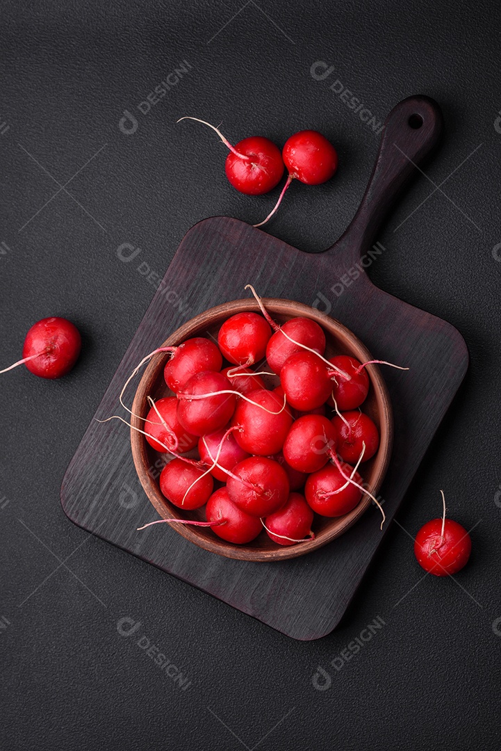 Delicioso rabanete vermelho cru fresco para fazer salada saudável em fundo escuro de concreto