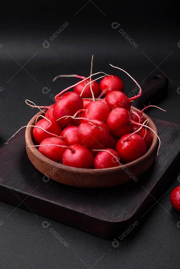 Delicioso rabanete vermelho cru fresco para fazer salada saudável em fundo escuro de concreto