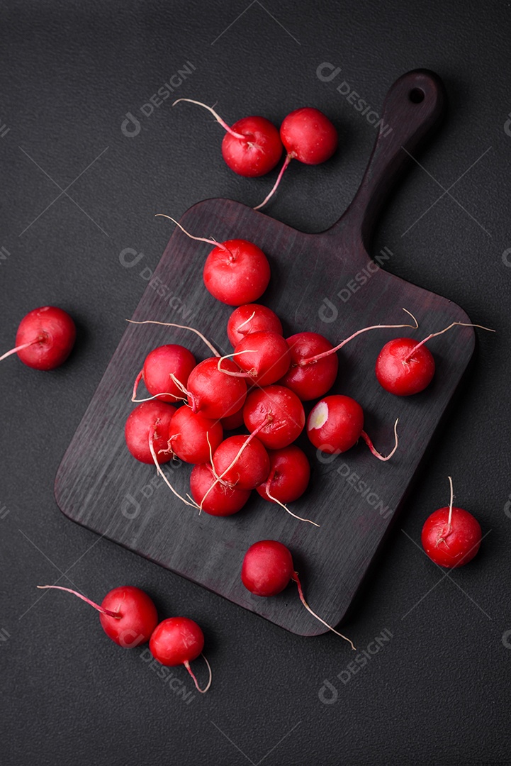 Delicioso rabanete vermelho cru fresco para fazer salada saudável em fundo escuro de concreto