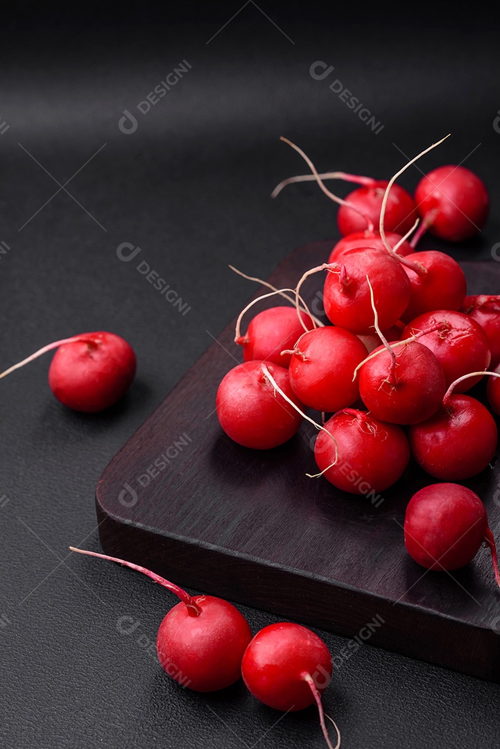 Delicioso rabanete vermelho cru fresco para fazer salada saudável em fundo escuro de concreto