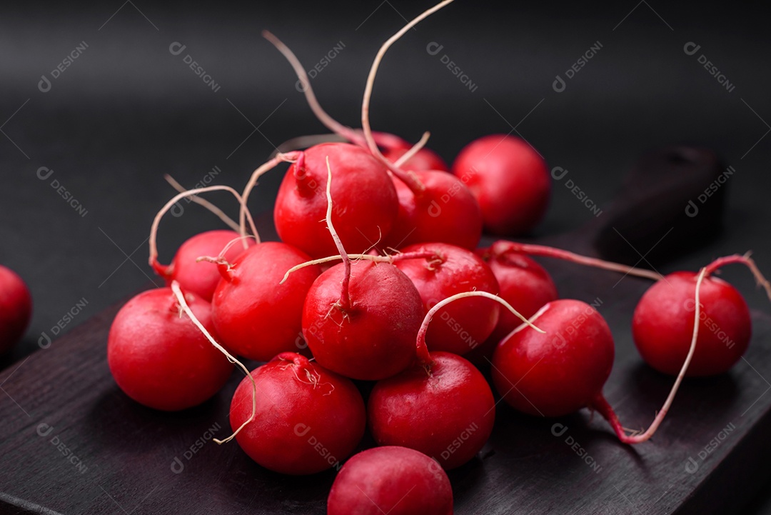 Delicioso rabanete vermelho cru fresco para fazer salada saudável em fundo escuro de concreto