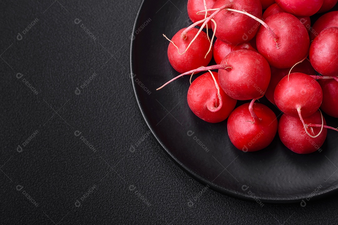 Delicioso rabanete vermelho cru fresco para fazer salada saudável em fundo escuro de concreto