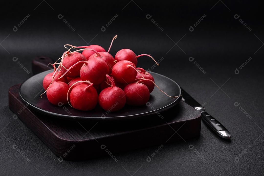 Delicioso rabanete vermelho cru fresco para fazer salada saudável em fundo escuro de concreto