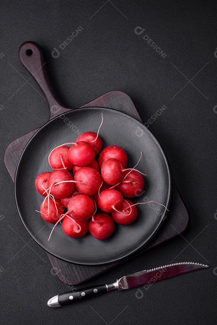Delicioso rabanete vermelho cru fresco para fazer salada saudável em fundo escuro de concreto