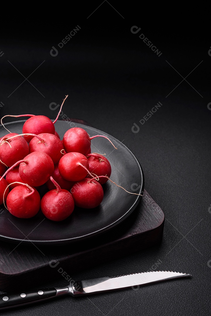 Delicioso rabanete vermelho cru fresco para fazer salada saudável em fundo escuro de concreto