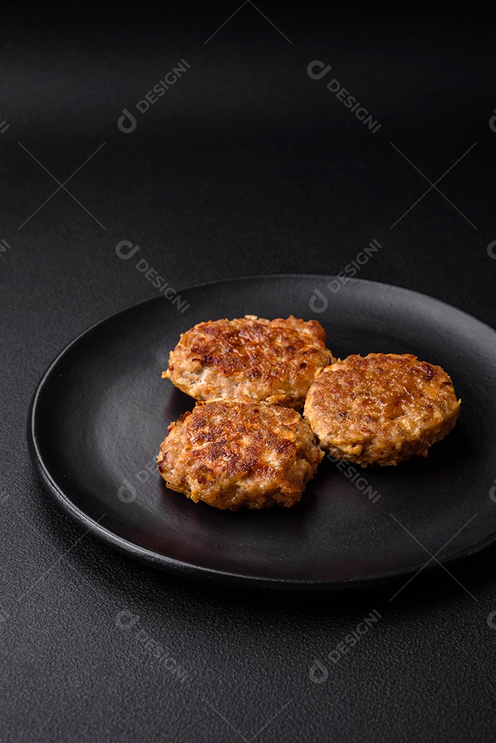 Deliciosas costeletas de peixe picado frito fresco com especiarias e ervas sobre um fundo escuro de concreto