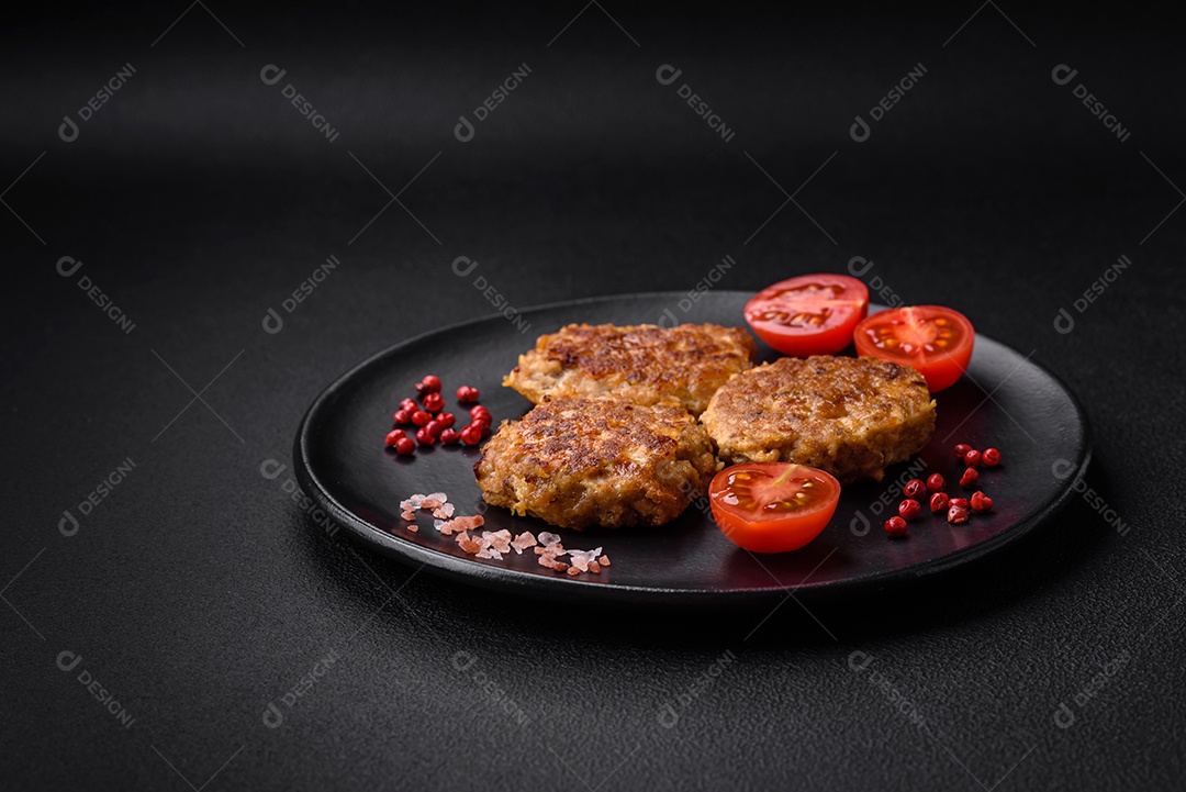 Deliciosas costeletas de peixe picado frito fresco com especiarias e ervas sobre um fundo escuro de concreto
