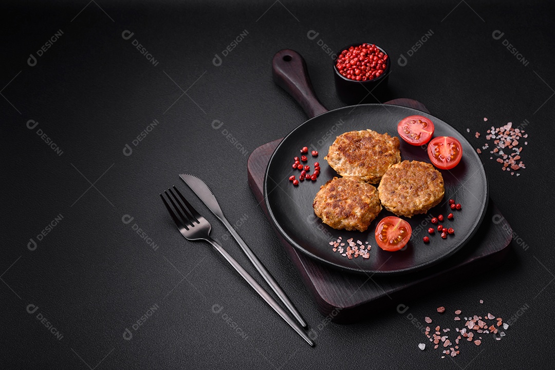 Deliciosas costeletas de peixe picado frito fresco com especiarias e ervas sobre um fundo escuro de concreto