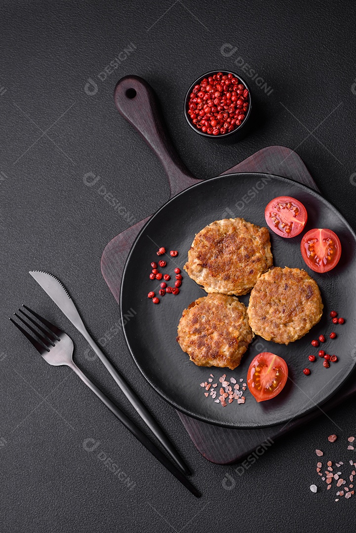 Deliciosas costeletas de peixe picado frito fresco com especiarias e ervas sobre um fundo escuro de concreto