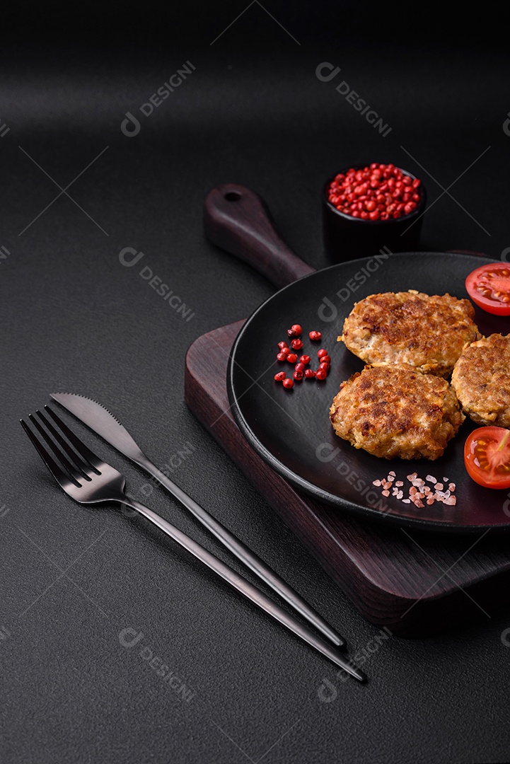 Deliciosas costeletas de peixe picado frito fresco com especiarias e ervas sobre um fundo escuro de concreto