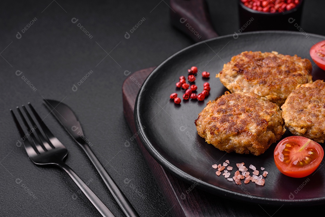 Deliciosas costeletas de peixe picado frito fresco com especiarias e ervas sobre um fundo escuro de concreto