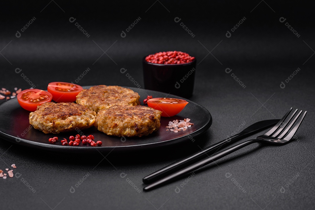 Deliciosas costeletas de peixe picado frito fresco com especiarias e ervas sobre um fundo escuro de concreto