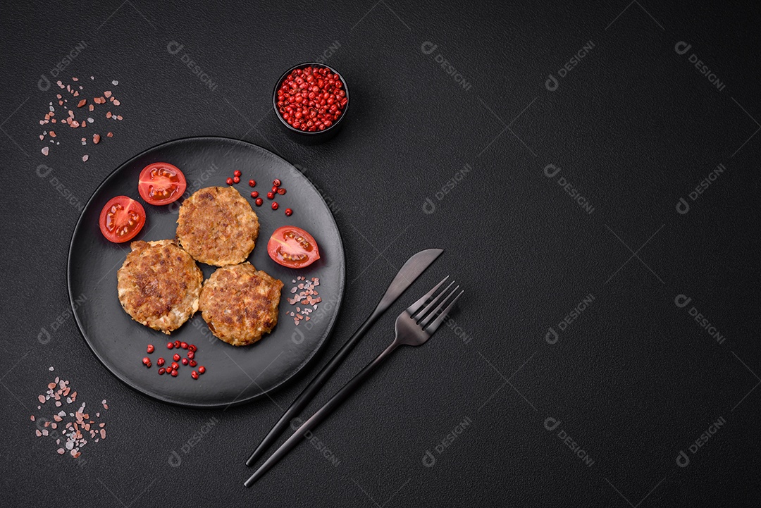 Deliciosas costeletas de peixe picado frito fresco com especiarias e ervas sobre um fundo escuro de concreto