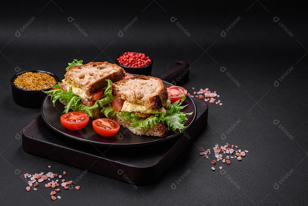 Delicioso sanduíche caprese com torradas grelhadas, mussarela, alface e tomate sobre fundo escuro de concreto