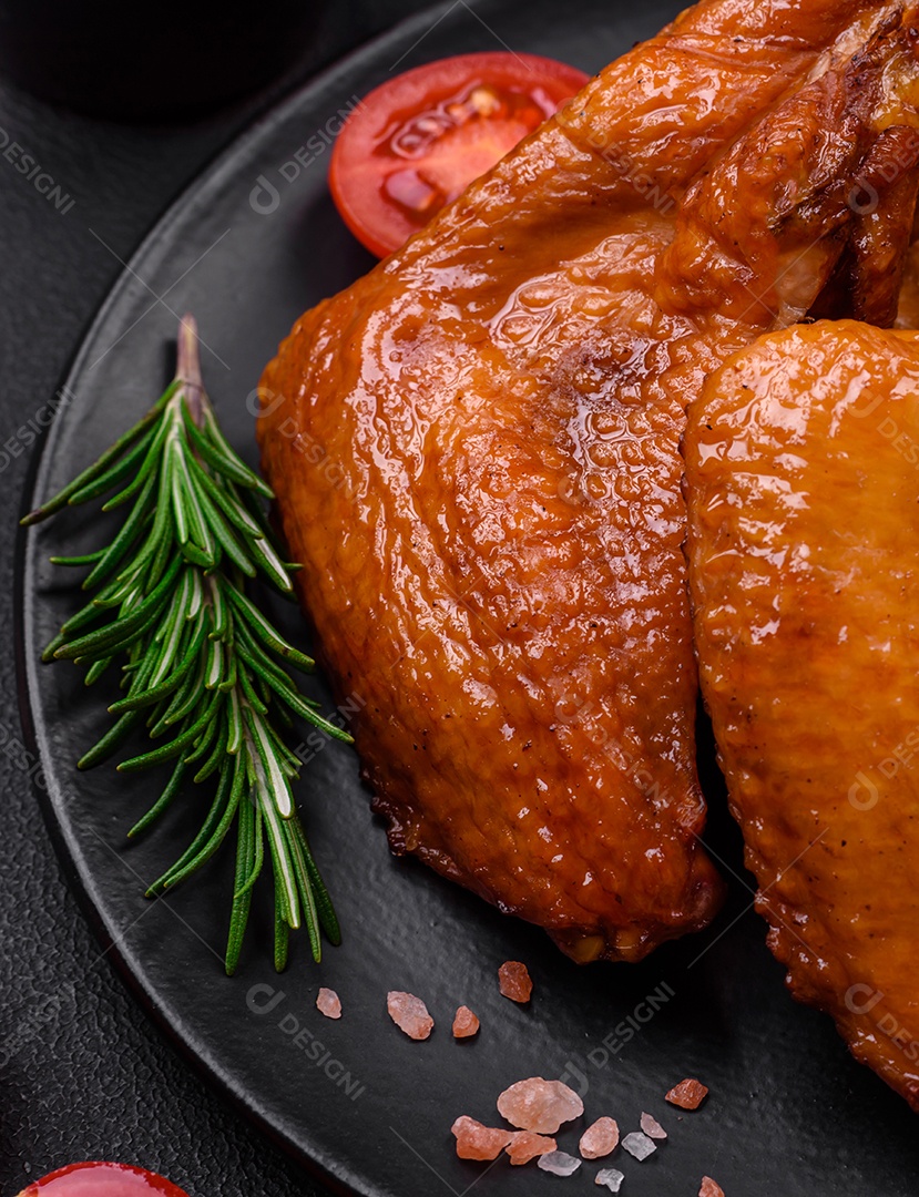 Deliciosas asas de frango grelhado com especiarias e ervas em um fundo escuro de concreto