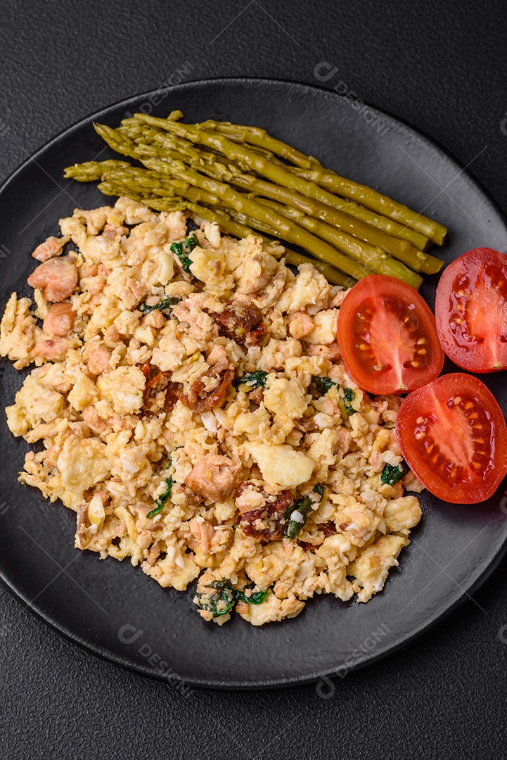 Deliciosa mistura com salmão, tomate seco, espinafre, especiarias e ervas em fundo escuro