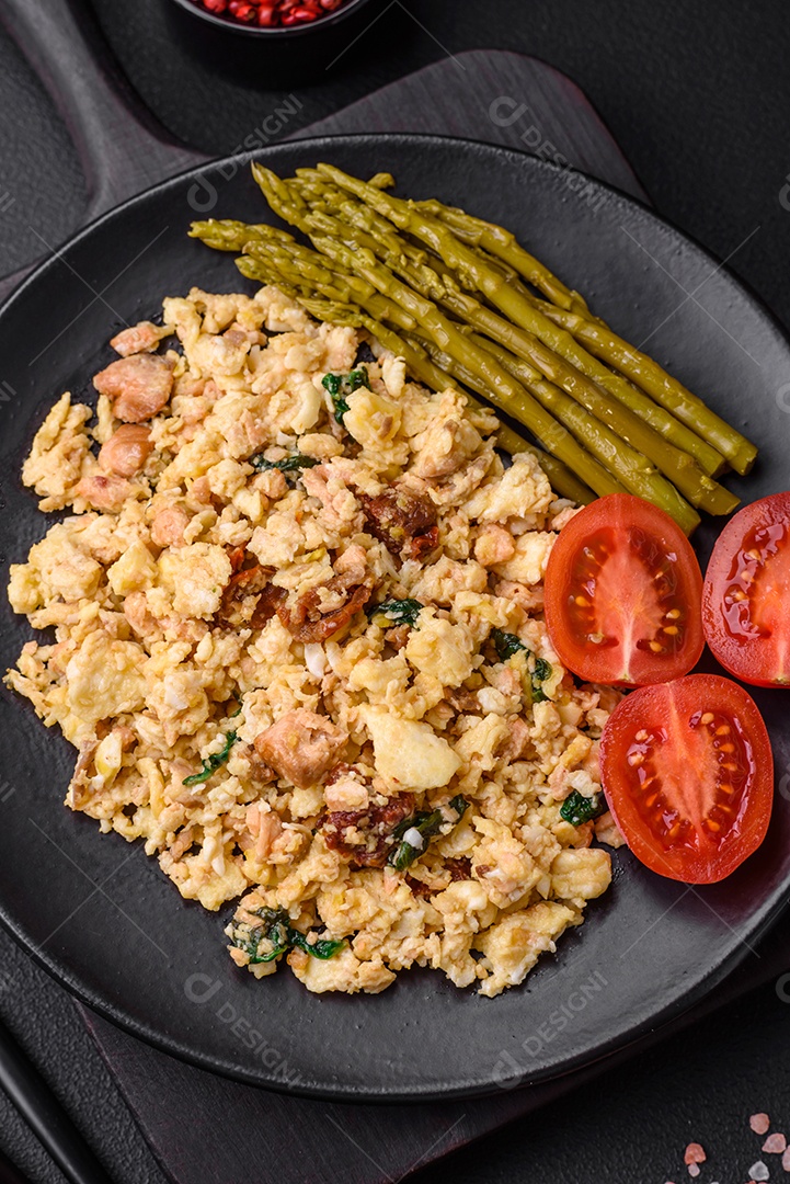 Deliciosa mistura com salmão, tomate seco, espinafre, especiarias e ervas em fundo escuro