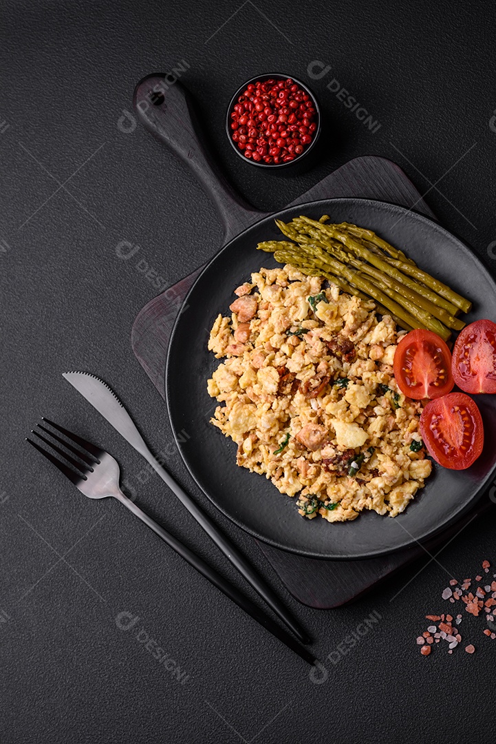 Deliciosa mistura com salmão, tomate seco, espinafre, especiarias e ervas em fundo escuro