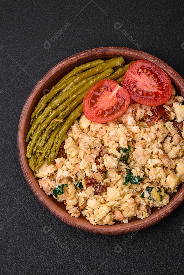 Deliciosa mistura com salmão, tomate seco, espinafre, especiarias e ervas em fundo escuro
