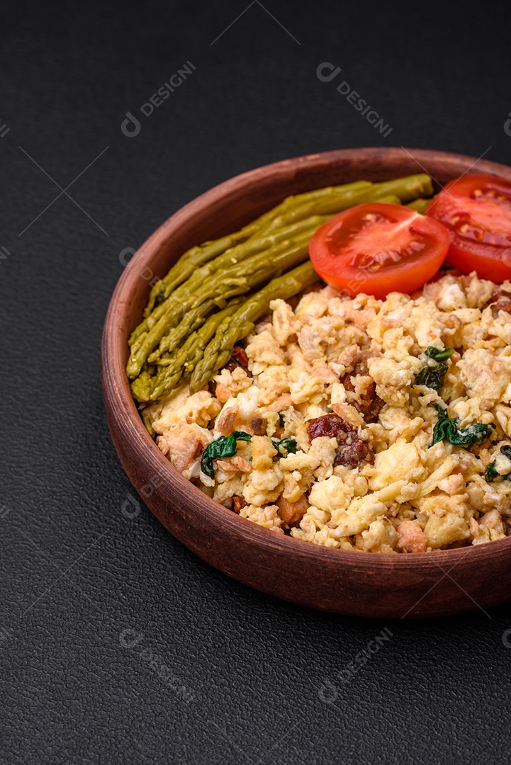Deliciosa mistura com salmão, tomate seco, espinafre, especiarias e ervas em fundo escuro