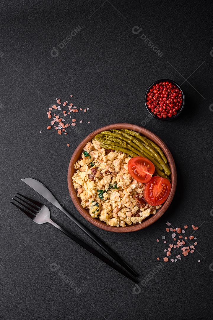 Deliciosa mistura com salmão, tomate seco, espinafre, especiarias e ervas em fundo escuro