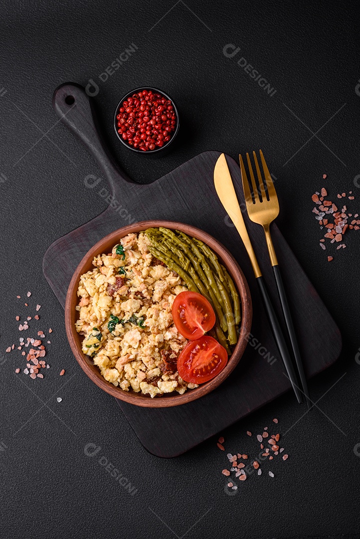 Deliciosa mistura com salmão, tomate seco, espinafre, especiarias e ervas em fundo escuro