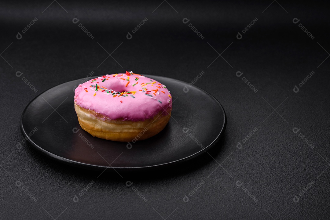 Delicioso donut com recheio de creme e nozes em um fundo escuro de concreto. Comida doce