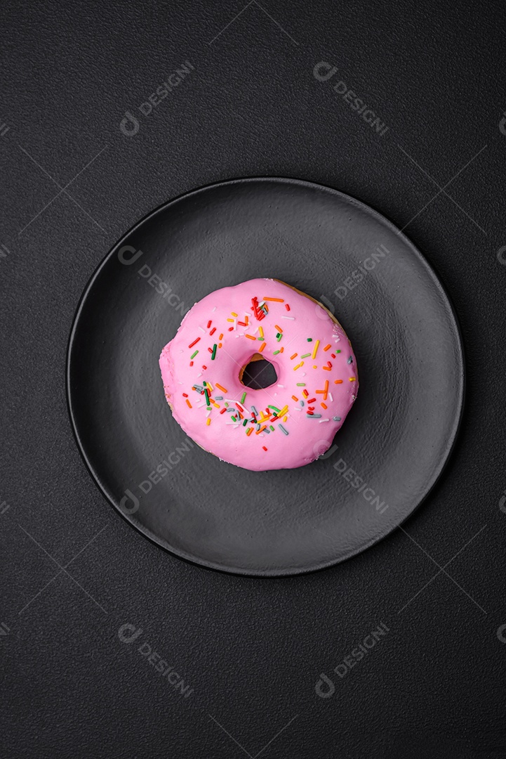 Delicioso donut com recheio de creme e nozes em um fundo escuro de concreto. Comida doce
