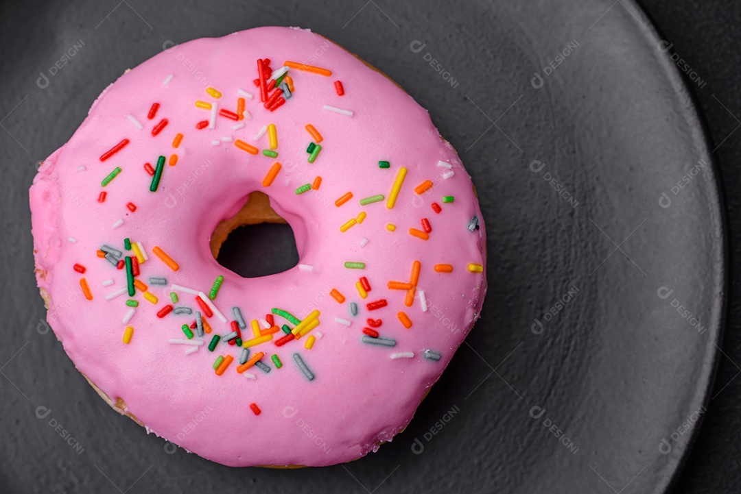 Delicioso donut com recheio de creme e nozes em um fundo escuro de concreto. Comida doce