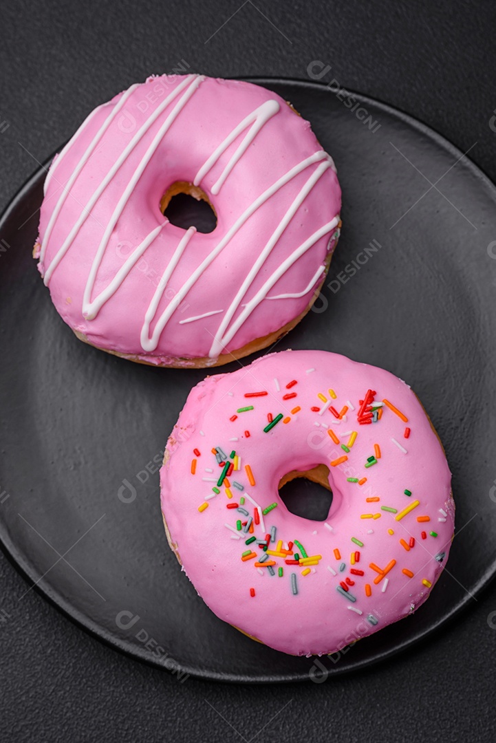 Delicioso donut com recheio de creme e nozes em um fundo escuro de concreto. Comida doce