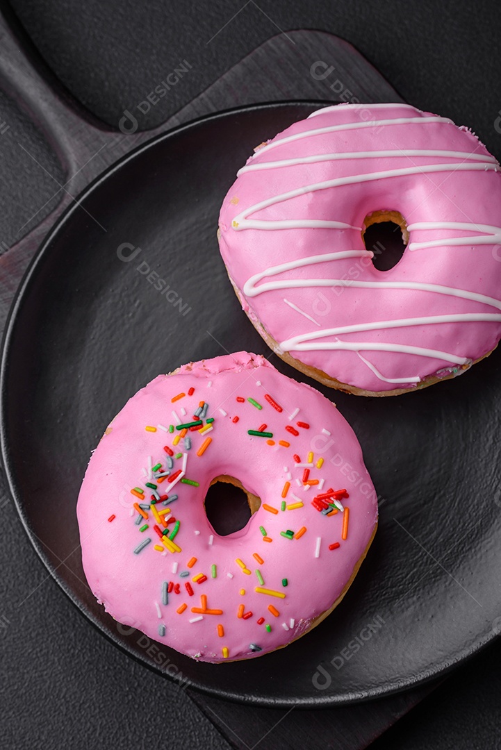Delicioso donut com recheio de creme e nozes em um fundo escuro de concreto. Comida doce