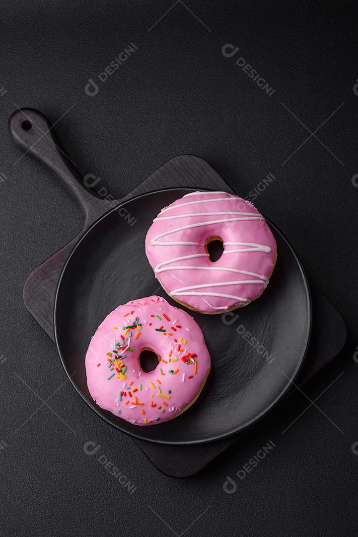 Delicioso donut com recheio de creme e nozes em um fundo escuro de concreto. Comida doce