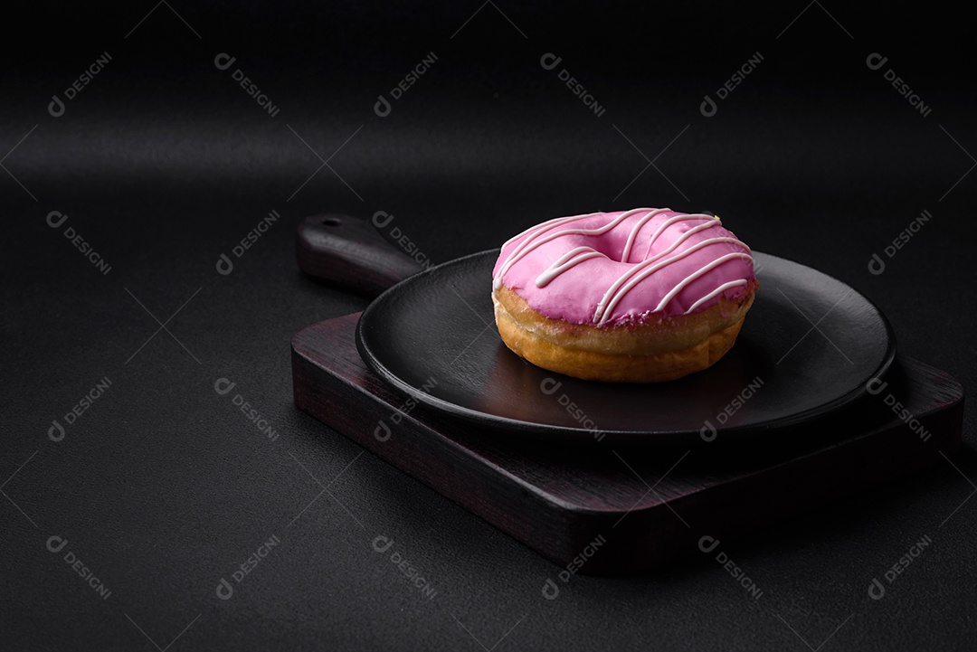 Delicioso donut com recheio de creme e nozes em um fundo escuro de concreto. Comida doce